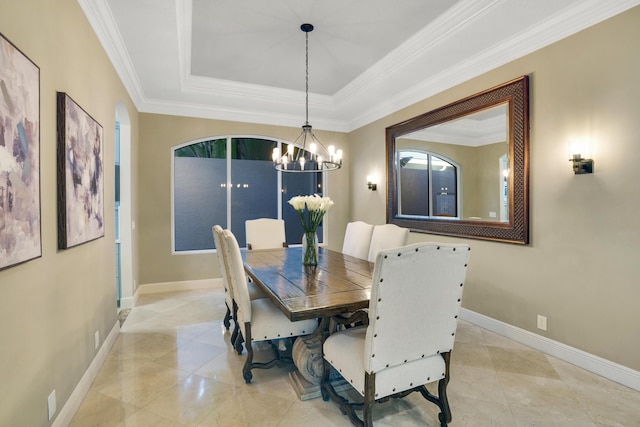 dining space with a raised ceiling, ornamental molding, and an inviting chandelier