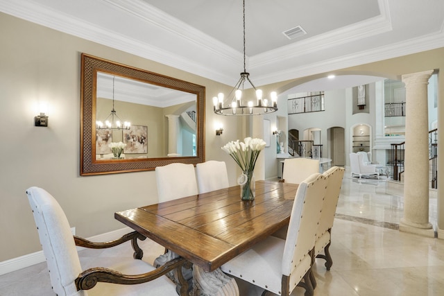 dining room featuring a tray ceiling, ornate columns, crown molding, and a notable chandelier