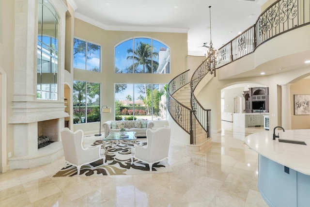 dining room featuring a fireplace, a healthy amount of sunlight, sink, and crown molding