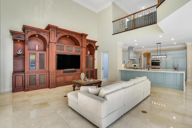 living room featuring sink, a high ceiling, and ornamental molding