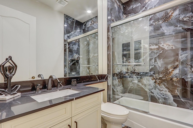 full bathroom with vanity, toilet, and enclosed tub / shower combo