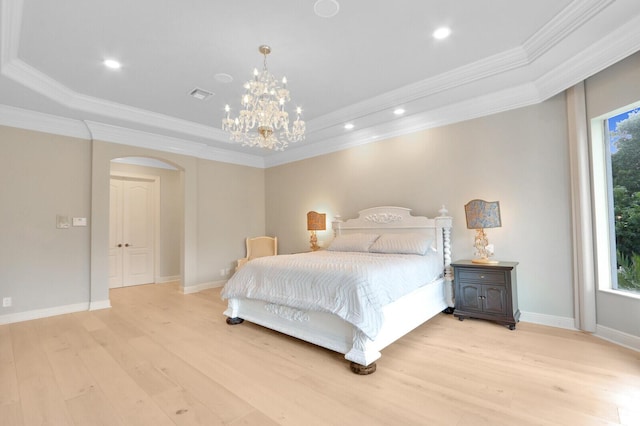 bedroom with light hardwood / wood-style floors, a raised ceiling, multiple windows, and ornamental molding