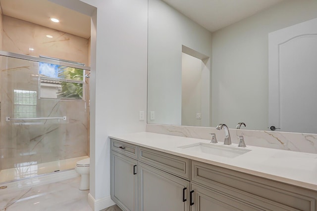 bathroom with vanity, toilet, and a shower with shower door