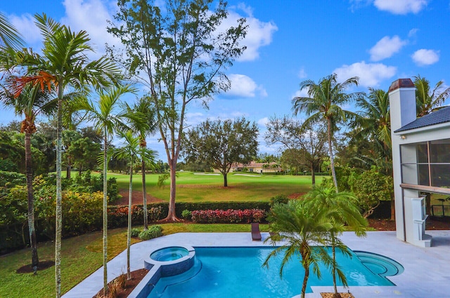 view of swimming pool featuring a lawn and an in ground hot tub