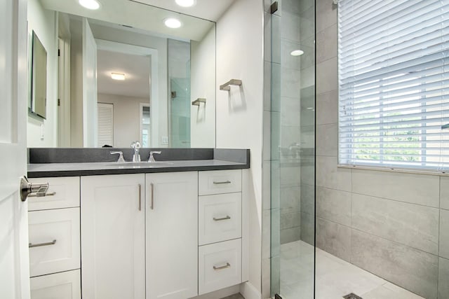 bathroom featuring tile patterned floors, vanity, and tiled shower