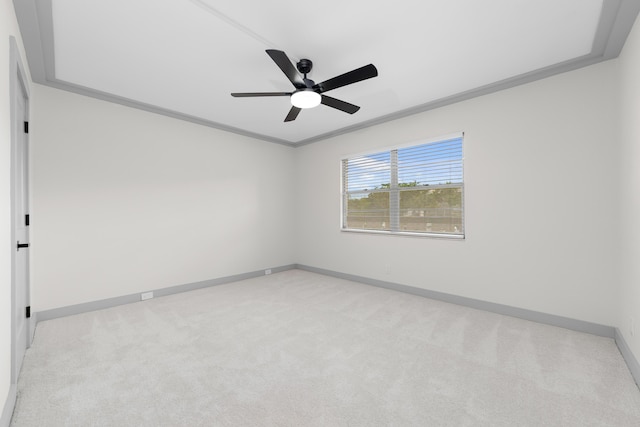 spare room featuring light carpet, ceiling fan, and ornamental molding