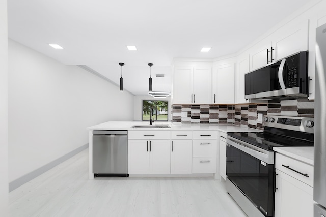 kitchen featuring white cabinets, pendant lighting, sink, and appliances with stainless steel finishes