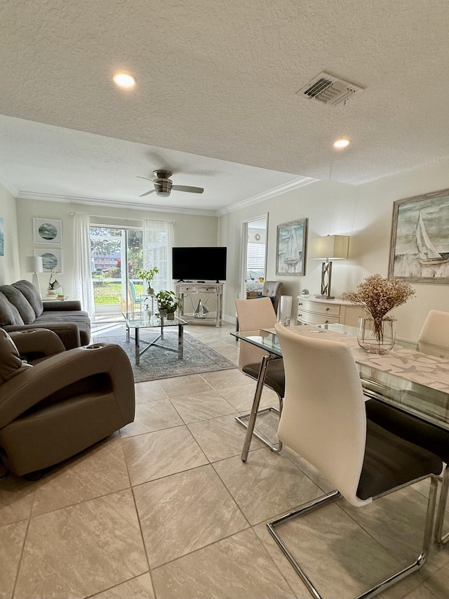 living room with light tile patterned floors, a textured ceiling, ceiling fan, and ornamental molding