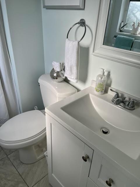 bathroom featuring tile patterned flooring, vanity, and toilet