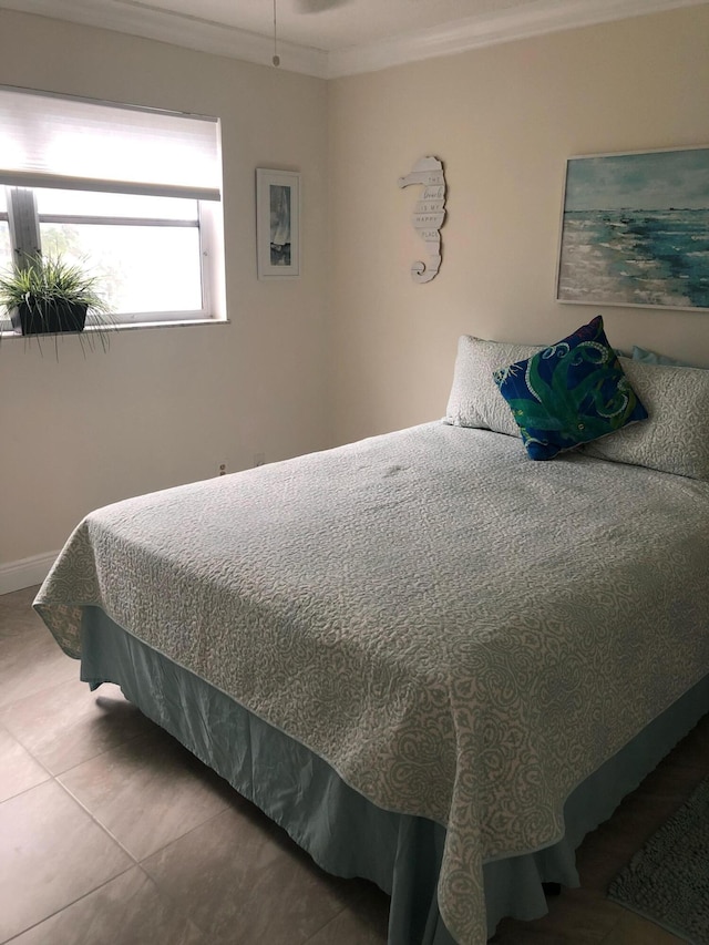 bedroom with tile patterned flooring and crown molding