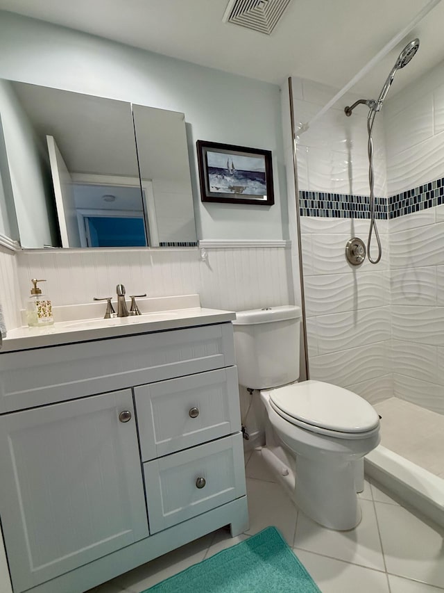 bathroom with decorative backsplash, vanity, tiled shower, tile patterned flooring, and toilet