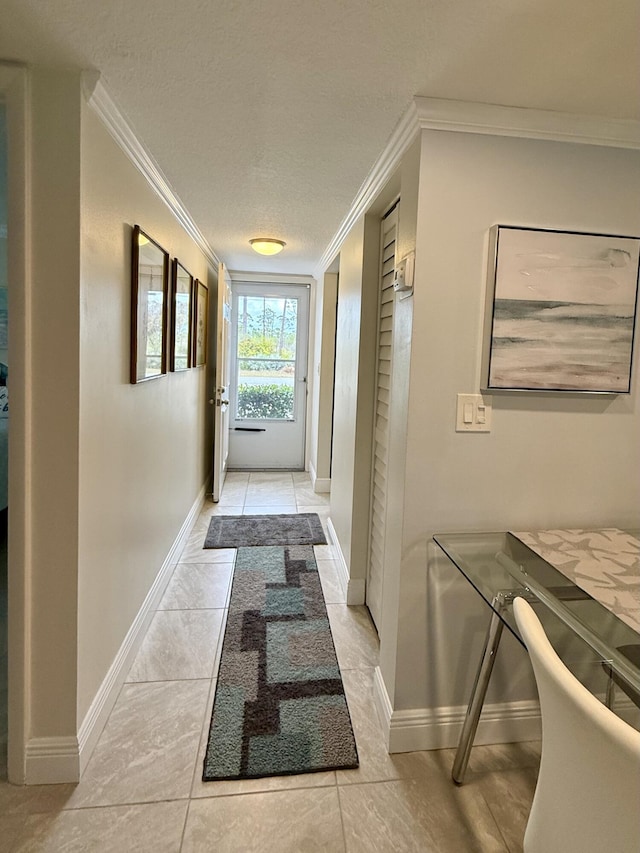 hallway with crown molding, light tile patterned flooring, and a textured ceiling