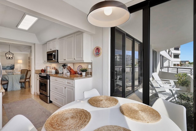 dining area with plenty of natural light, light tile patterned floors, and vaulted ceiling