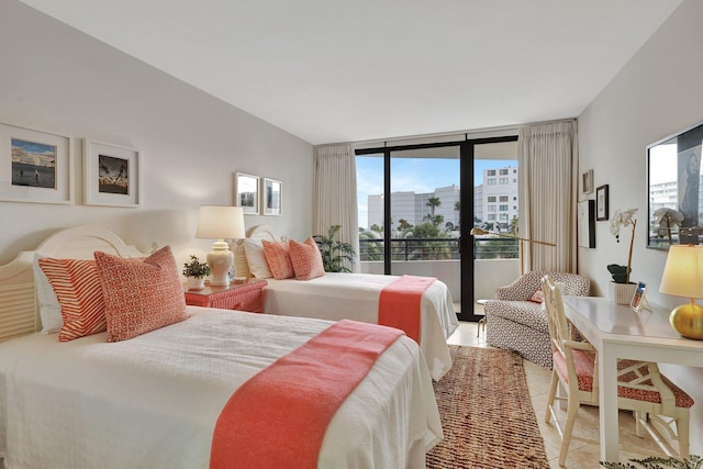 bedroom with access to exterior, light tile patterned flooring, and a wall of windows