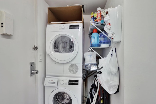 washroom featuring stacked washer / drying machine