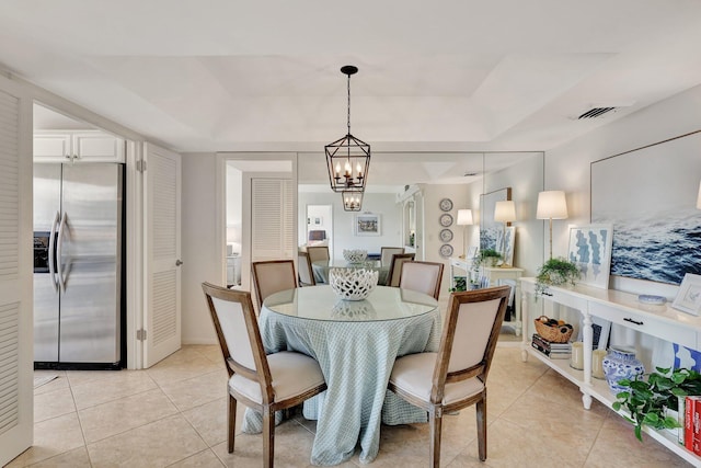 tiled dining room with a notable chandelier