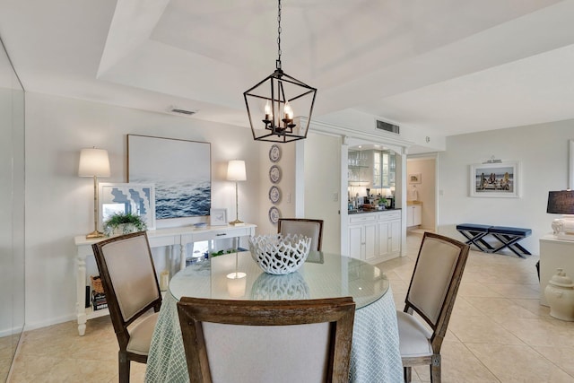 tiled dining room featuring an inviting chandelier