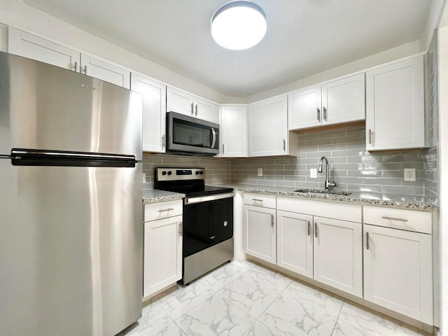 kitchen with decorative backsplash, stainless steel appliances, white cabinetry, and sink