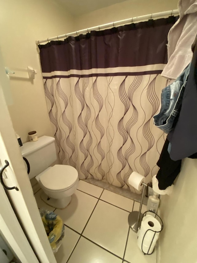 bathroom with tile patterned floors, toilet, and walk in shower