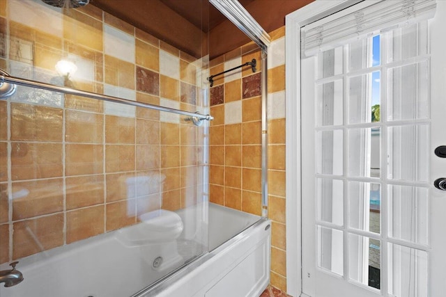 bathroom featuring bath / shower combo with glass door