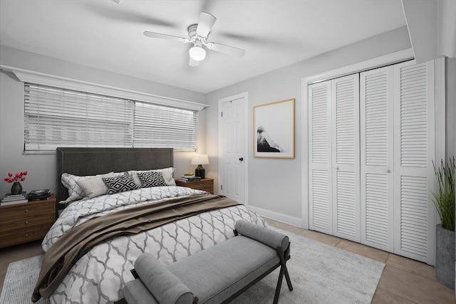 tiled bedroom featuring ceiling fan and a closet