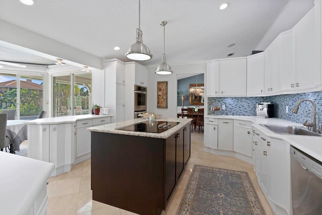 kitchen with white cabinets, appliances with stainless steel finishes, a center island, and sink