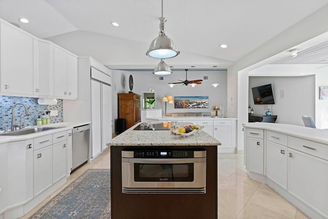 kitchen featuring pendant lighting, sink, vaulted ceiling, white cabinetry, and stainless steel appliances