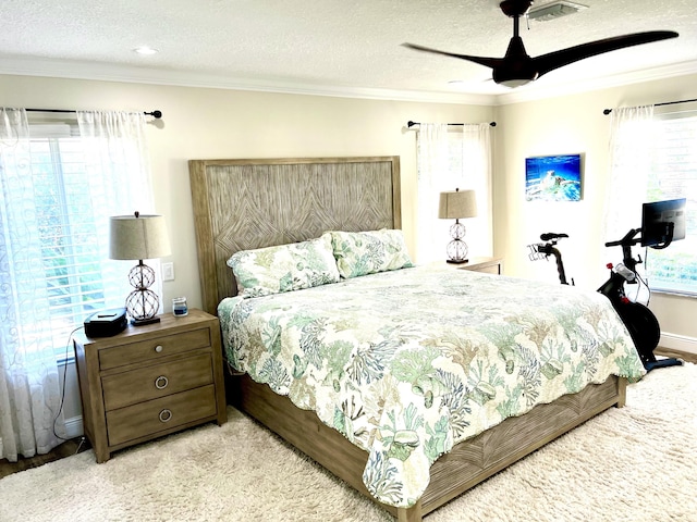 bedroom featuring ceiling fan, a textured ceiling, and ornamental molding