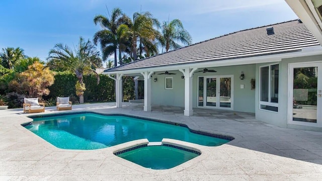 view of swimming pool with ceiling fan, a patio area, and an in ground hot tub