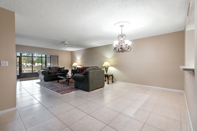 tiled living room featuring ceiling fan with notable chandelier and a textured ceiling