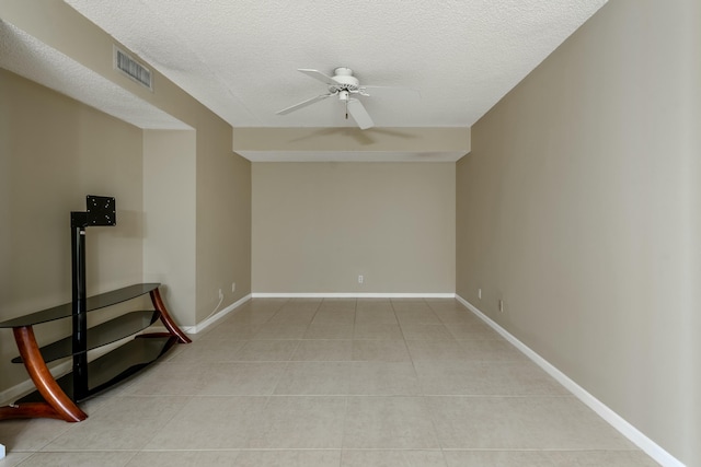 empty room with light tile patterned floors, a textured ceiling, and ceiling fan