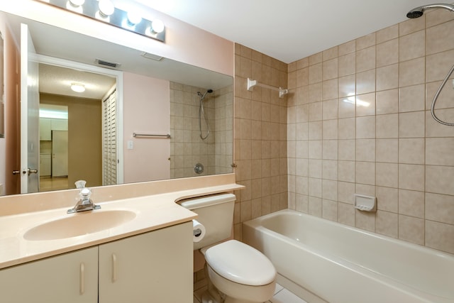 full bathroom with tiled shower / bath, vanity, and toilet