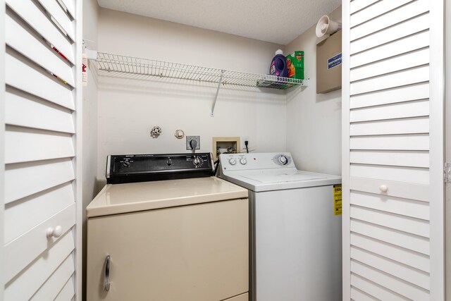 laundry room featuring separate washer and dryer and a textured ceiling