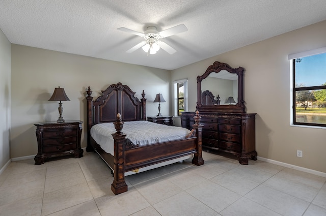 tiled bedroom featuring ceiling fan, multiple windows, and a textured ceiling