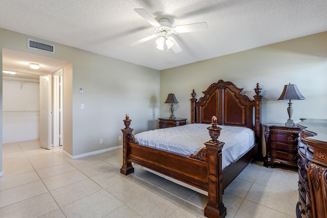 tiled bedroom featuring ceiling fan and a textured ceiling