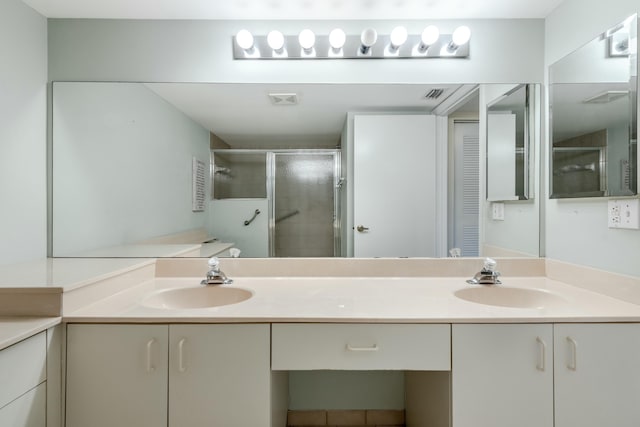 bathroom with a shower with door and vanity