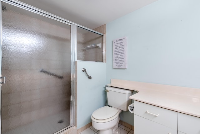 bathroom with vanity, toilet, a shower with shower door, and tile patterned flooring