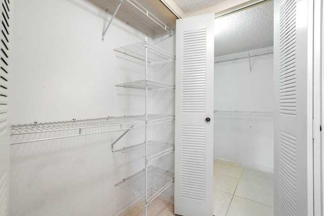 spacious closet featuring light tile patterned flooring