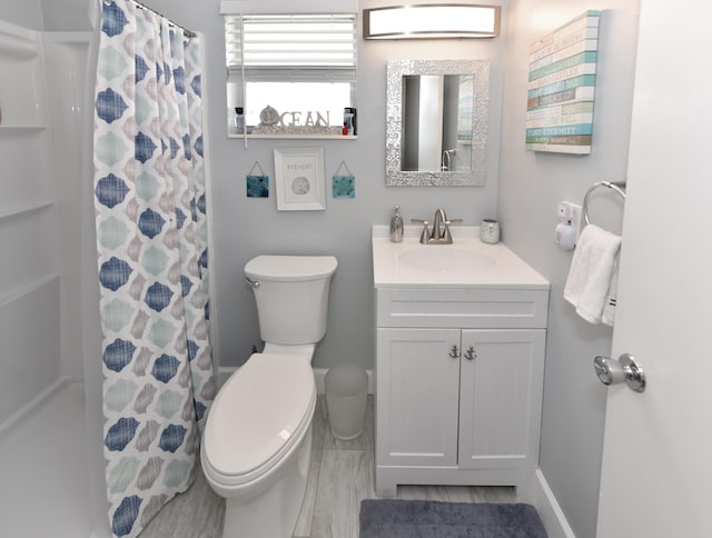 bathroom featuring a shower with curtain, toilet, and vanity