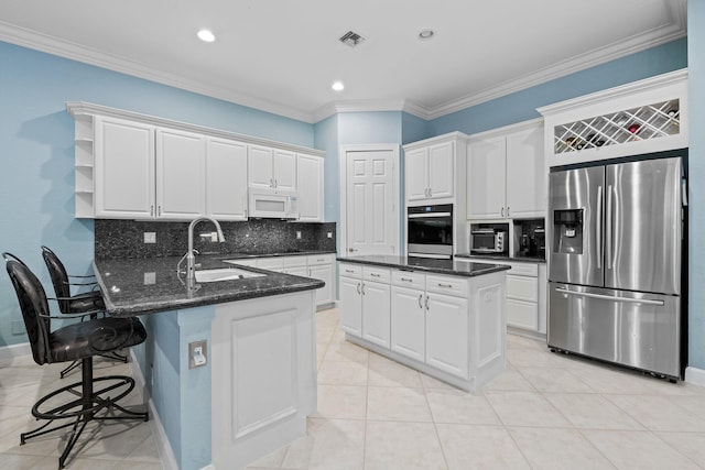 kitchen featuring appliances with stainless steel finishes, backsplash, white cabinetry, and sink