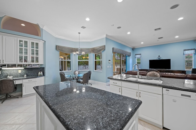 kitchen featuring white dishwasher, sink, white cabinets, and a kitchen island with sink