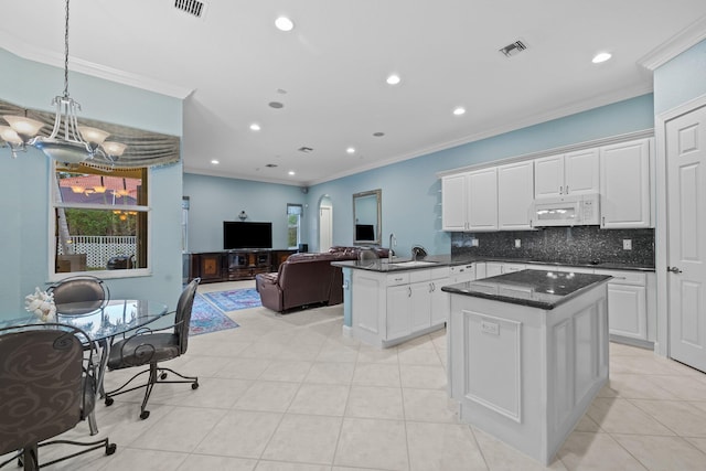 kitchen with white cabinetry, kitchen peninsula, backsplash, and light tile patterned floors