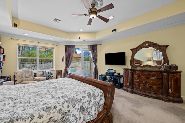 bedroom with ornamental molding, access to outside, light colored carpet, ceiling fan, and a tray ceiling