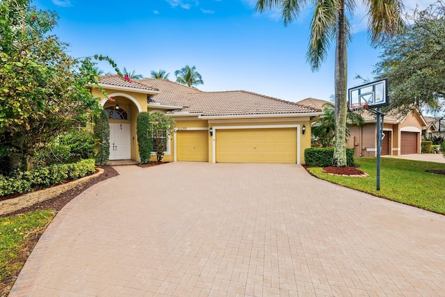 mediterranean / spanish-style home with a front yard and a garage