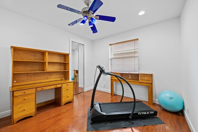 exercise area featuring light wood-type flooring and ceiling fan