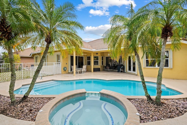 view of swimming pool featuring a patio area and an in ground hot tub