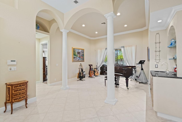 interior space featuring sink, ornate columns, crown molding, and light tile patterned floors