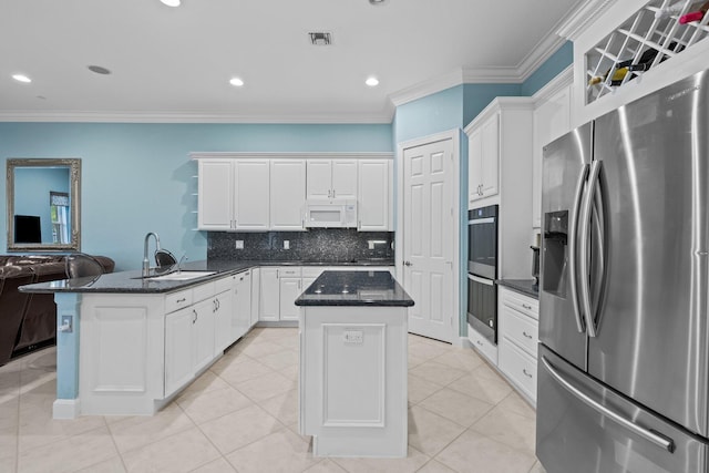 kitchen with kitchen peninsula, stainless steel appliances, sink, white cabinets, and a center island