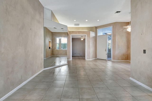 empty room with ceiling fan and light tile patterned floors