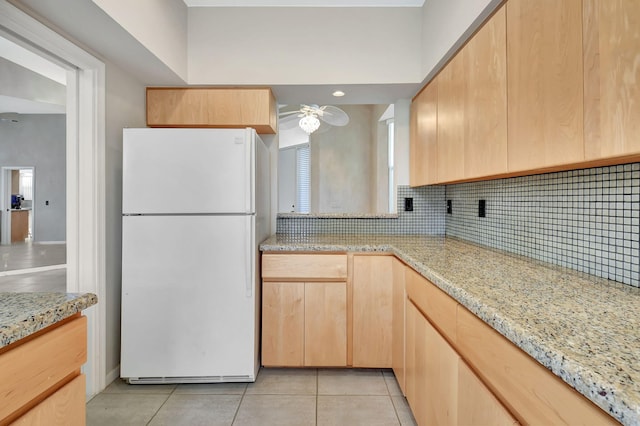 kitchen with decorative backsplash, light brown cabinets, light tile patterned flooring, and white refrigerator